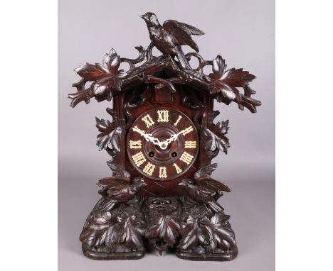 A mahogany cased Black Forest cuckoo mantel clock with carved decoration depicting nesting birds. Height 54cm.  Pediment loos