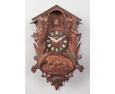 A Black Forest cuckoo clock with carved Lion of Lucerne decoration.  Decoration loose.