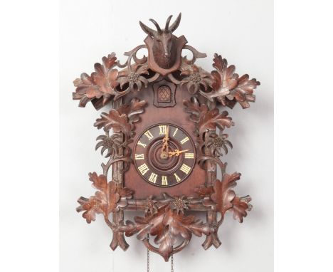 A black forest style cuckoo clock, with decorative carved deer pediment.  Missing pendulum, pediment has been restored.