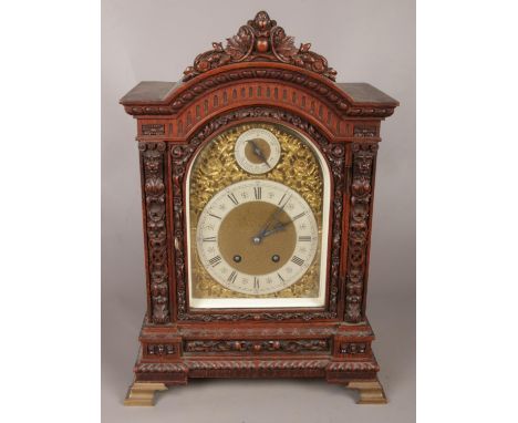 A 19th century carved oak bracket clock by Lenzkirch. Brass arched dial with silvered chapter ring and subsidiary slow fast d