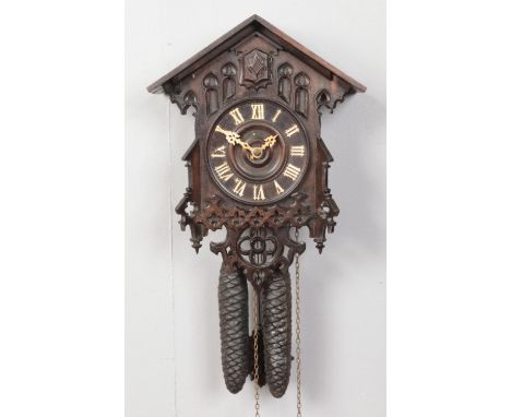 A Black Forest cuckoo clock with pierced Gothic decoration.  