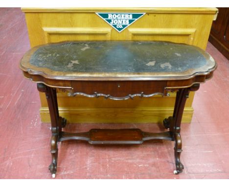 A VICTORIAN SHAPED TOP AND CARVED MAHOGANY SINGLE DRAWER WRITING TABLE with shelf cross rail on white pot castors (restoratio