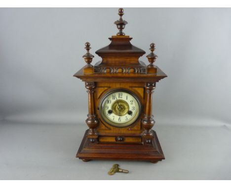 A CIRCA 1900 GERMAN WALNUT CASED MANTEL CLOCK, Wurttemberg make, fourteen day strike movement on a coiled gong, interior pape