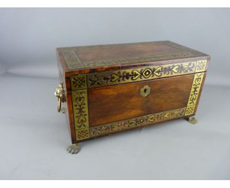 A REGENCY ROSEWOOD TEA CADDY with pierced brass banding, lion mask ring handles and hairy paw feet, the lined interior with b