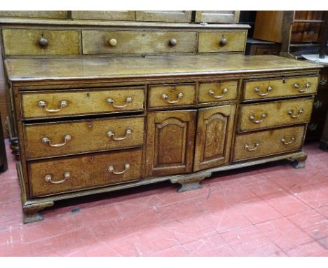 A GEORGE III OAK &amp; CROSSBANDED MAHOGANY LANCASHIRE DRESSER BASE, having a central two drawer and two door arrangement wit