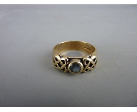 A NINE CARAT GOLD CELTIC RING with small topaz centre stone