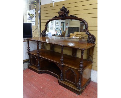 A HIGH VICTORIAN MAHOGANY SERVER with carved dog's head and fruit and vine detail to a mirrorback over a pillared top shelf a