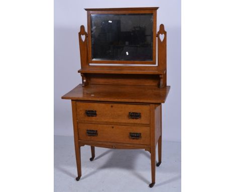 Edwardian oak dressing table, in the Arts and Crafts style, rectangular bevelled mirror back, with a raised shelf, two drawer