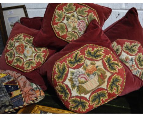 Five red velvet cushions, with floral tapestry panels.