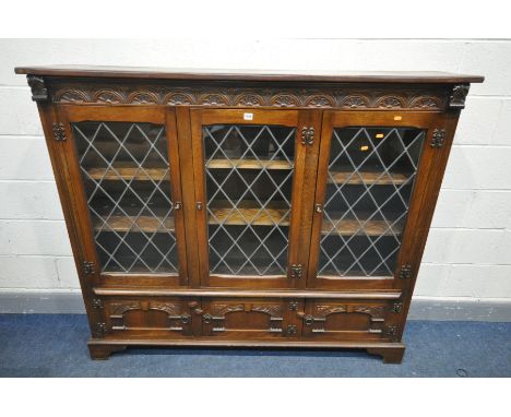 AN OAK LEAD GLAZED TRIPLE DOOR BOOKCASE, with three cupboard doors, on bracket feet, width 163cm x depth 34cm x height 140cm 