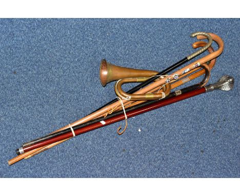 SIX WALKING STICKS/ CANES AND A COPPER AND BRASS BUGLE, the walking sticks to include two with white metal mounts, one mount 