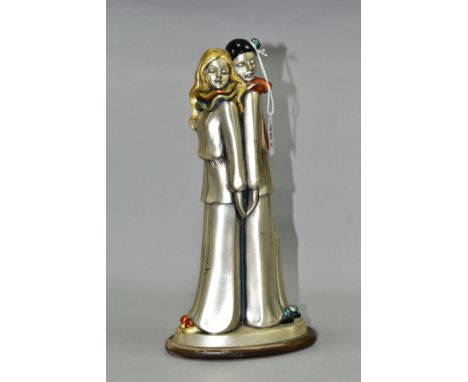 A SILVER LAMINATED FIGURE GROUP, comprising a male and female clown standing back to back, silver laminate with painted ename