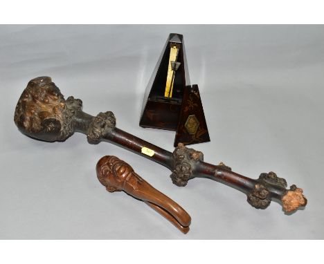 A PAIR OF EARLY 20TH CENTURY BLACK FOREST NUTCRACKERS IN THE FROM OF A BALD MAN WITH MOUSTACHE, together with a Metronome Sel