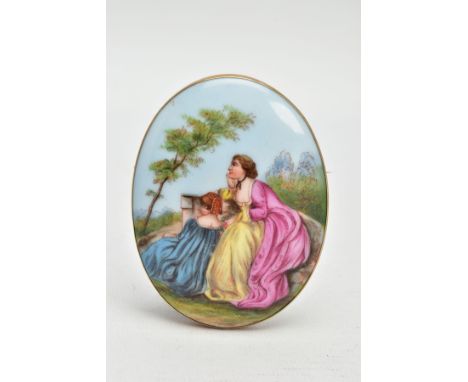 A LARGE PAINTED CERAMIC BROOCH, painted scene depicting two lady's in dresses sitting on a wall within a landscape, bezel set