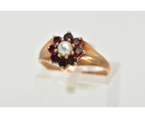 A 9CT GOLD GARNET AND PEARL CLUSTER RING, centring on a single cultured pearl, measuring approximately 3.5mm, within a surrou