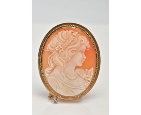 A 9CT GOLD CAMEO BROOCH, an oval shell cameo depicting a lady in profile in a collet mount with a rope twist surround, polish