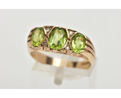 A MODERN 9CT GOLD SEVEN STONE DRESS RING, designed with three oval cut peridots, interspaced with four small single cut diamo