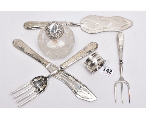 A SILVER MOUNTED CUT GLASS JAR, SILVER NAPKIN, SILVER HANDLED TRIDENT FORK AND A THREE PIECE WHITE METAL SET, the cut glass d