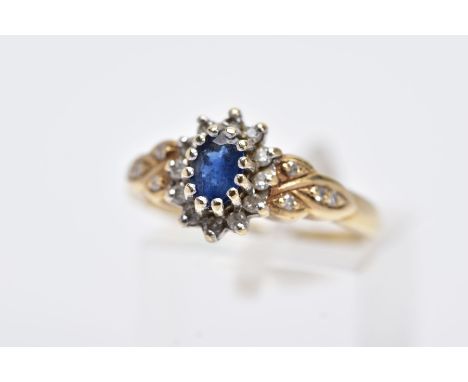 A 9CT GOLD SAPPHIRE AND DIAMOND CLUSTER RING, designed with a central claw set oval cut blue sapphire within a surround of ro