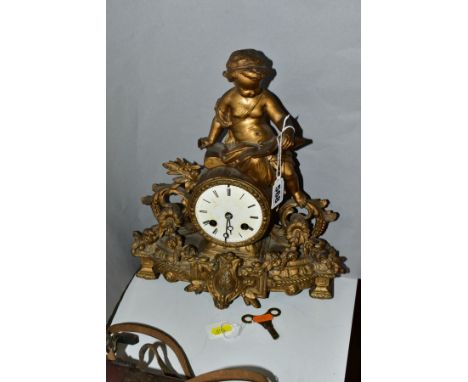 A LATE 19TH CENTURY FRENCH GILT METAL FIGURAL MANTEL CLOCK, the case cast with a putti holding an open book, the white enamel