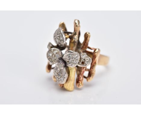 A YELLOW METAL DIAMOND SET RING, of a floral and bark textured design in the style of Andrew Grima, the flower set with singl