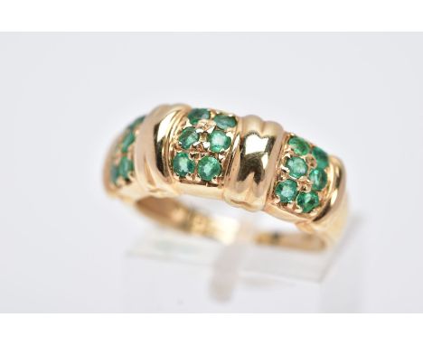 A 14CT GOLD EMERALD RING, designed with three sections each set with two rows of circular cut emeralds, hallmarked 14ct gold 