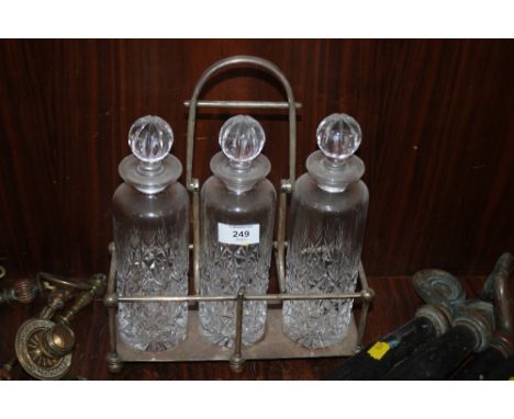 A SILVER PLATED THREE DECANTER TANTALUS