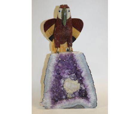 AN UNUSUAL CARVED GEM STONE PARROT ON AMETHYST GEODE STAND