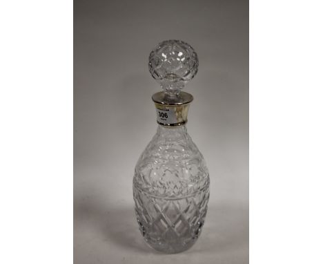 A HALLMARKED SILVER COLLARED CUT GLASS DECANTER
