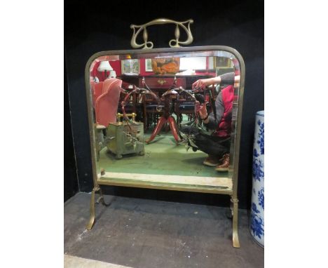 A brass Art Nouveau style mirrored fire screen 