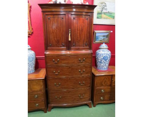 In the manner of Maple &amp; Co. an Edwardian mahogany bow-front tallboy, the two door cupboard with working locks and key ov