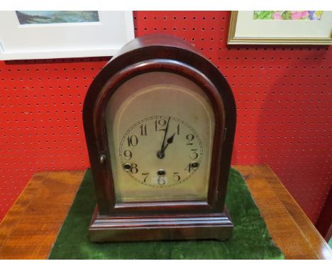 A dome clock with moulded wooden door and bevel edged glass