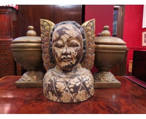 A carved wooden bust of a deity and a pair of ceramic lidded urns