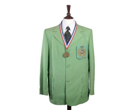A 1972 FITA OLYMPICS JACKET of bright green fabric, with three buttons and a large FITA XX Olympiad 1972 patch on the breast 