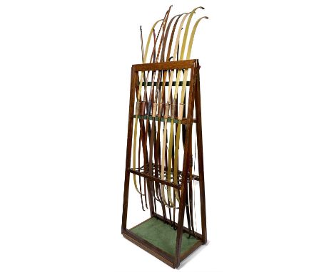 A FOLDING CONTINENTAL ARCHERY STAND WITH SIXTEEN CONTINENTAL BOWS, EARLY 20TH CENTURY of wood, comprising an A-frame with sep