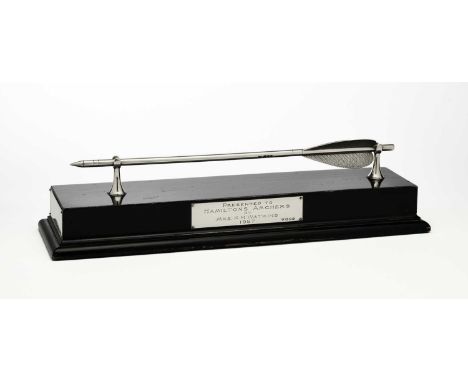 A PRESENTATION SILVER ARROW, GOLDSMITHS & SILVERSMITHS CO. LTD., LONDON, 1956 on two flared supports: on an ebonised wooden s