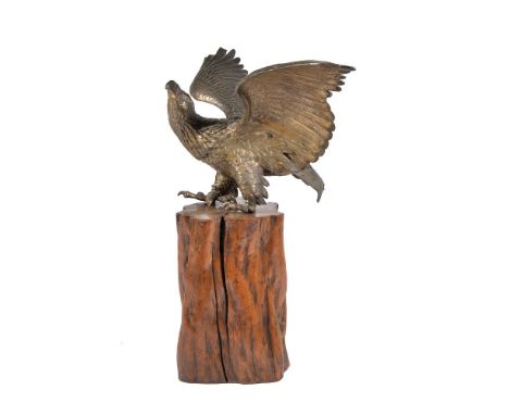 A Japanese Cast metal Model of an Eagle, the creature stands with head turned to its left and its wings spread, with traces o