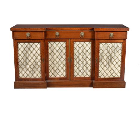 A Regency mahogany side cabinet, circa 1815, the central pair of pleated silk doors opening to a shelved interior, flanked by