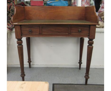 A late 19thC mahogany washstand, later fitted with a tooled and gilded hide scriber, over two box drawers, raised on ring tur