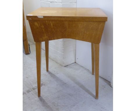 A mid 20thC light oak cased sewing table, raised on square, tapered legs&nbsp; 31"h&nbsp; 24"w incorporating a Singer electri