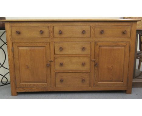 A 20thC light oak dresser, comprising three inline drawers, over three central drawers, flanked by a pair of fielded panelled