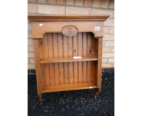 A stained pine kitchen shelf unit.