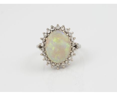 OPAL RING WG 585. Ringmaß ca. 54.5. Ges.-Gew.: 5,76 g. Ein Opal Cabochon ca. 15,15 x 11,90 mm; 22 Brillanten, zusammen ca. 0.