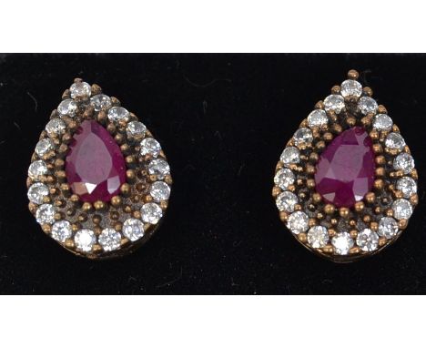 A pair of 925 silver Art Deco style earrings set with a central CZ red stone surrounded by a CZ halo in the shape of a tear d