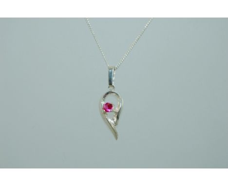 A vintage sterling silver pendant necklace with silver swirl pendant set with pink stone. Marked Sterling Silver. Measures 17