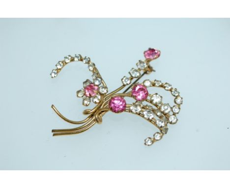 A large vintage yellow metal floral spray brooch set with clear and pink paste stones with roller clasp. Weight 9.6g. Measure