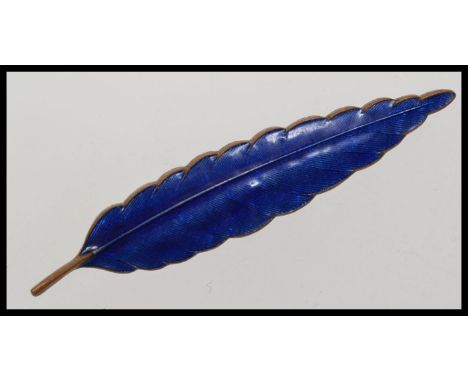 A vintage blue enamel brooch in the shape of a feather.