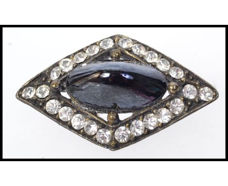 A 1930s Art Deco metal brooch set with paste stones with central blue black cabochon reminiscent of a muscle shell. Weight 19