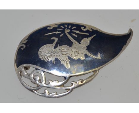 A silver niello brooch with etched figure with roller clasp. Weight 4.8g. Measures 4.5cms.