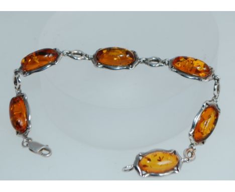 A 925 silver bracelet set with amber cabouchons in Art Nouveau style silver links with lobster claw clasp. Marked 925. Measur